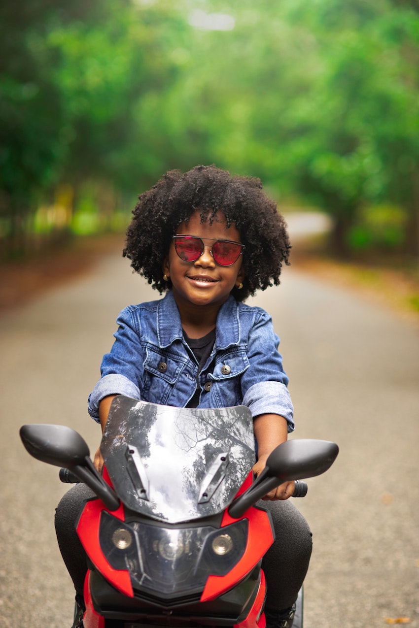 Kids Health - 10 Reasons Children Should Wear Sunglasses - Girl on bike wearing sunglasses